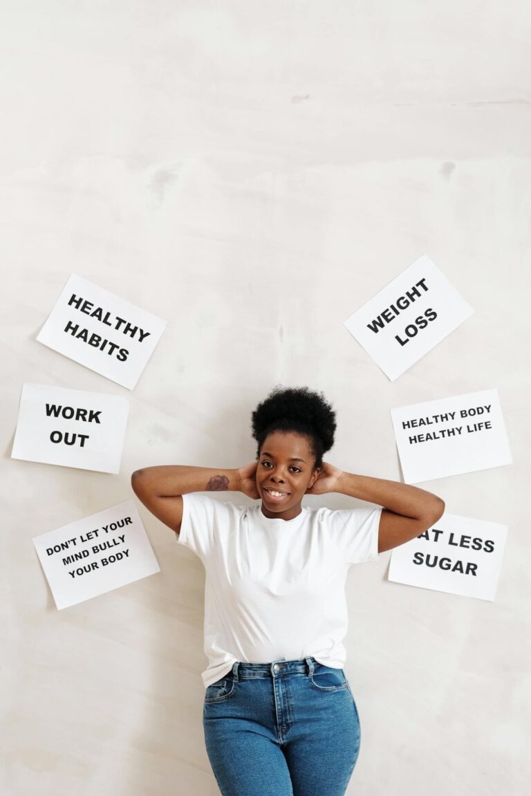Woman standing against a wall with motivational slogans promoting health and fitness.